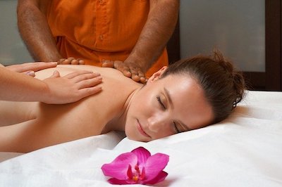 Woman getting massaged by two people