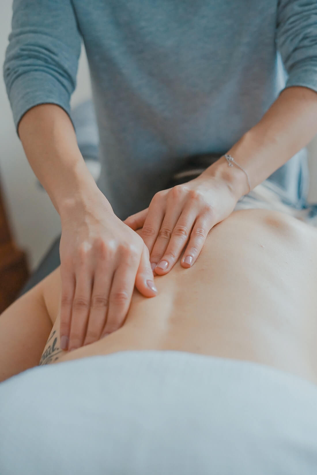 Hands on person's back using the bowen technique